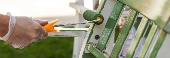Hand streicht Gartenstuhl grün